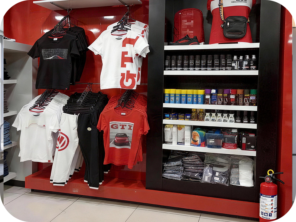 Retail display of clothing and automotive supplies with a red fire extinguisher at the aisle edge