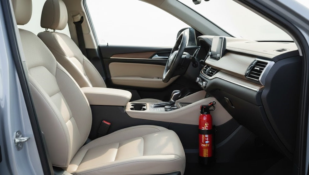 Red fire extinguisher mounted beside the front passenger footwell in a car