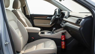 Red fire extinguisher mounted beside the front passenger footwell in a car